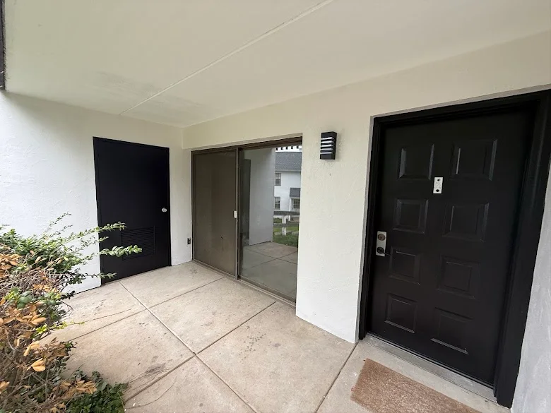 Black exterior doors on white stucco entry