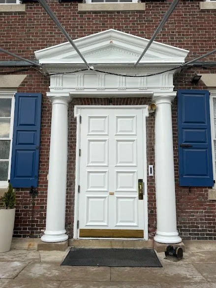 White colonial entry door with columns and blue shutters painted by Andy's Painting LLC