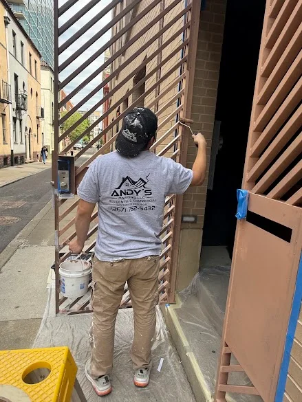 Andy's Painting LLC crew painting a storefront gate