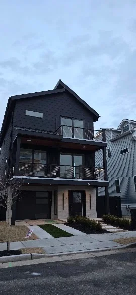 Modern three-story home with dark exterior finish painted by Andy's Painting LLC